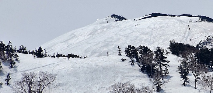 手前の急な斜面が燧ケ岳・広沢田代上の急斜面で、この斜面の奥に広大な熊沢田代があります。俎嵓の広大な斜面で春スキーを楽しむ人々や、山頂を目指して登る人々の姿が見えます。