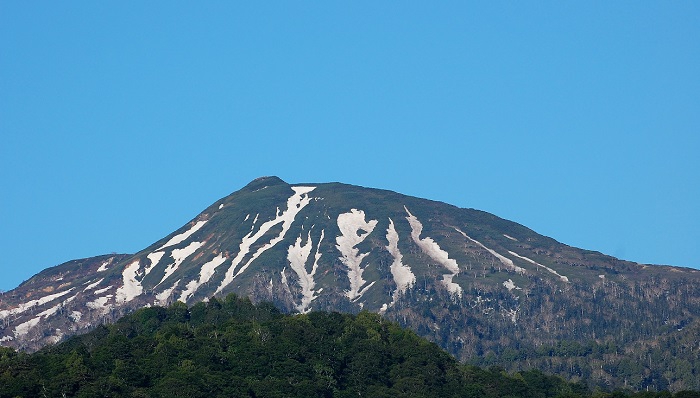 雪解けの進む燧ケ岳(標高２３５６ｍ）。残雪の形の中に鍛冶ばさみの形が見られる季節となりました。