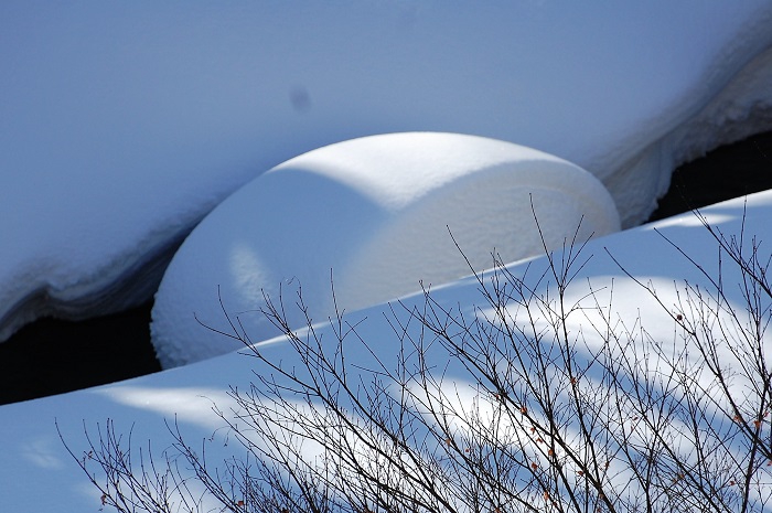 妻と二人で、この雪景色を冬の檜枝岐川渓谷のロールケーキと名づけ、いつも尾瀬野から見つめていました。屋根から降ろした雪の除雪作業の中で、冬の渓谷の光景を見つめて（２０２２年２月２６日）。