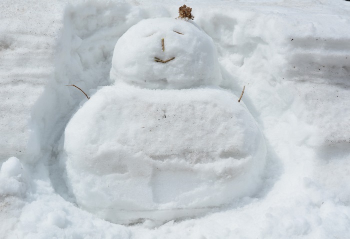 厳しく長い冬の終りに、雪の壁沿いに雪ダルマを製作し見つめて（２０２４年３月２８日・尾瀬野駐車場国道向かいにて）。
