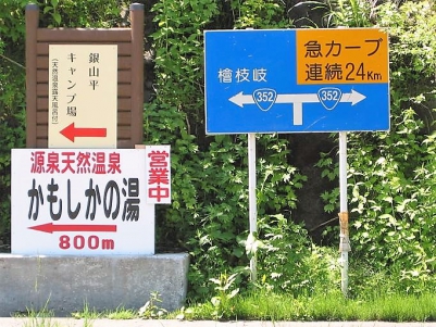 奥只見シルバーライン出口にございます、檜枝岐村方面と、枝折峠方面へのＴ字路にある看板です。銀山平には、キャンプ場もありますが、「かもしかの湯」という温泉公衆浴場もございます。